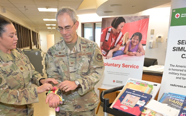 Maj. Bonnie Sgroi, 60th Inpatient Squadron clinical nurse specialist, demonstrates one of the sensory tools to Col. Patrick Parsons