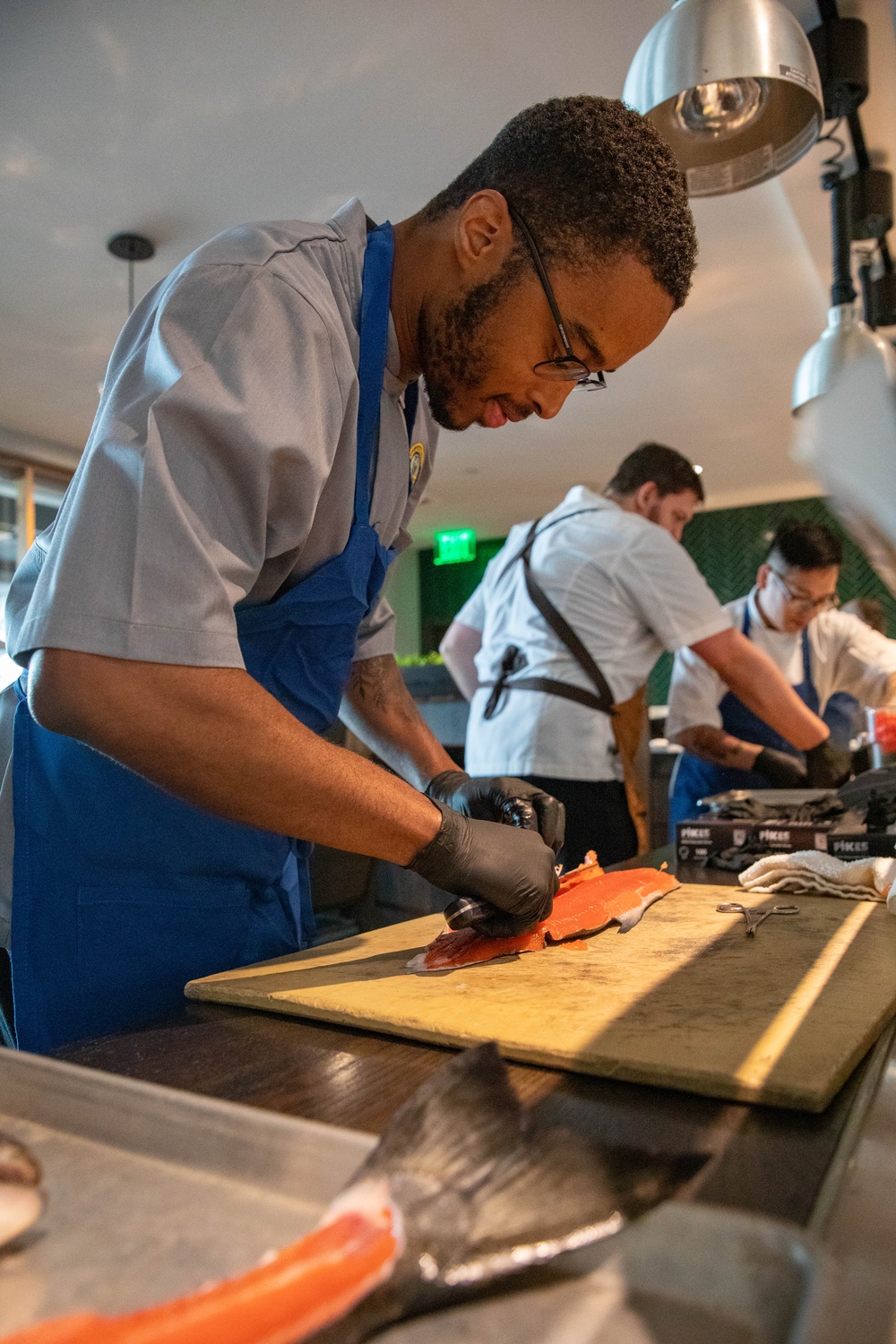Navy and Coast Guard culinary specialists take a cooking lesson during Seattle Fleet Week 2025