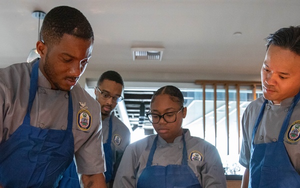 Navy and Coast Guard culinary specialists take a cooking lesson during Seattle Fleet Week 2025