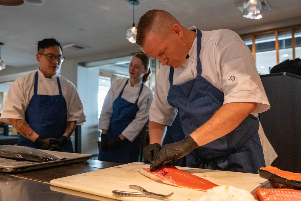 Navy and Coast Guard culinary specialists take a cooking lesson during Seattle Fleet Week 2025