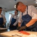 Navy and Coast Guard culinary specialists take a cooking lesson during Seattle Fleet Week 2025