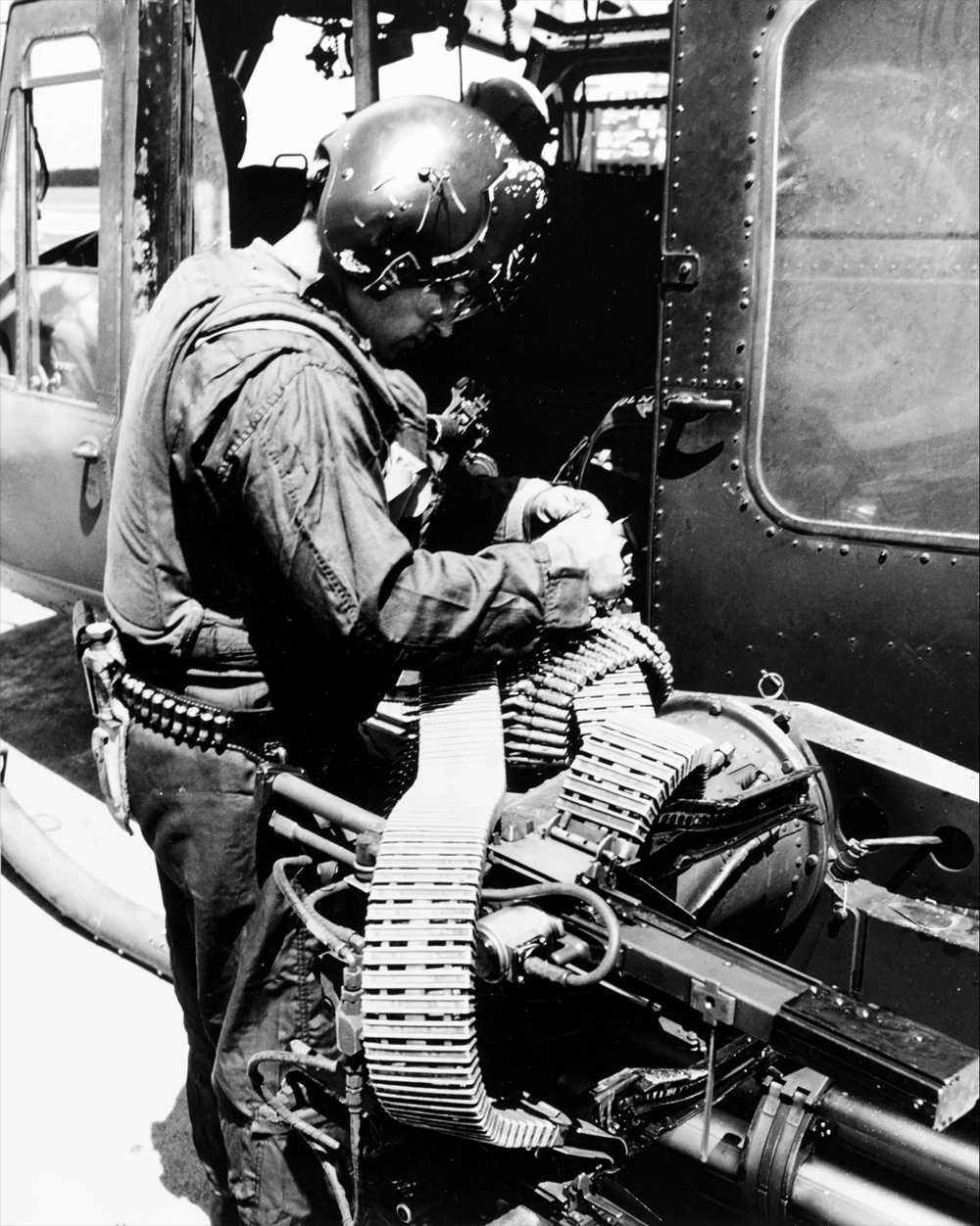 Upscale image of Seawolf HA(L)-3 Gunship U.S. Navy crewman reloads M60 machine gun of a HA(L)-3 UH-1B aboard USS Harnett County (LST821), Vietnam, 10 September 1969 (K-58290)