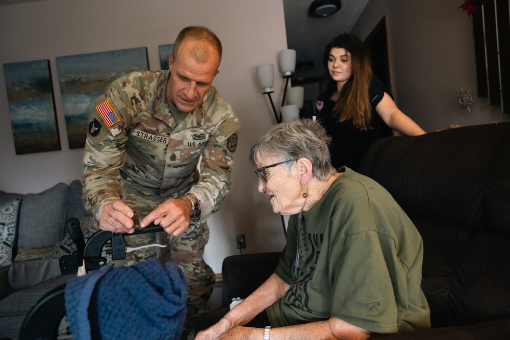 Command Sgt. Maj. Matthew Strasser presents coin to Iowa Army veteran