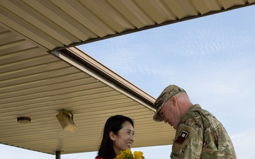 Soldier Hands Yellow Roses to Spouse