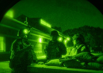 Airmen stand watch at night during Exercise Northern Strike 25-2