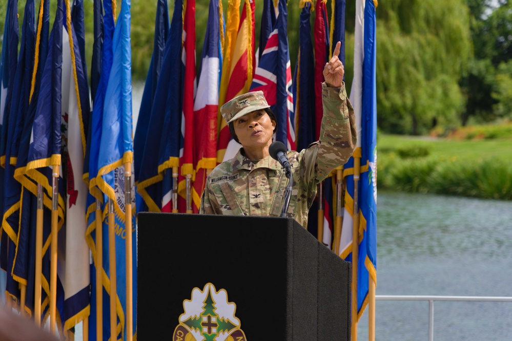 Col. Hope M. Williamson-Younce points up to attendees observing from above Swan Plaza and addresses the staff and supporters of Madigan Army Medical Center