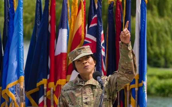 Col. Hope M. Williamson-Younce points up to attendees observing from above Swan Plaza and addresses the staff and supporters of Madigan Army Medical Center
