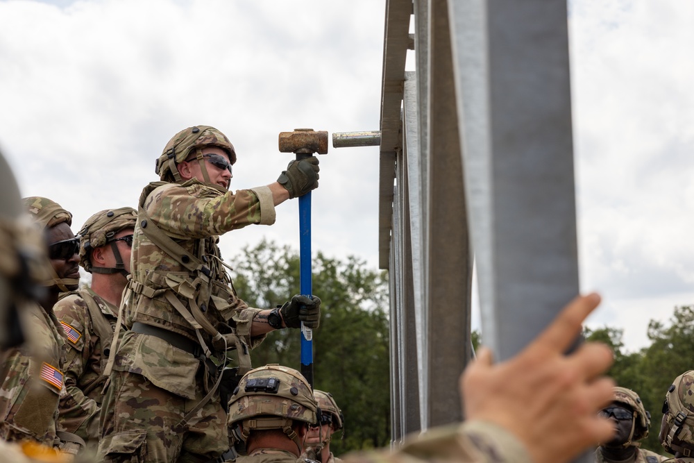 Soldier Hammers Pin into Place