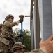Soldier Hammers Pin into Place