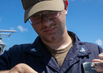 USS Mitscher (DDG 57) Sailor conducts bridge maintenance