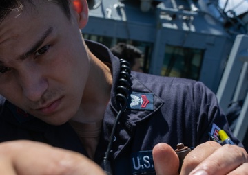USS Mitscher (DDG 57) Sailor conducts bridge maintenance