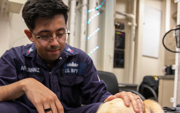 USS Mitscher (DDG 57) Sailor greets USS Gerald R. Ford (CVN 78) working dog