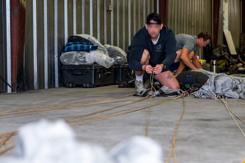 NSWG2 personnel prepare parachutes for AE25