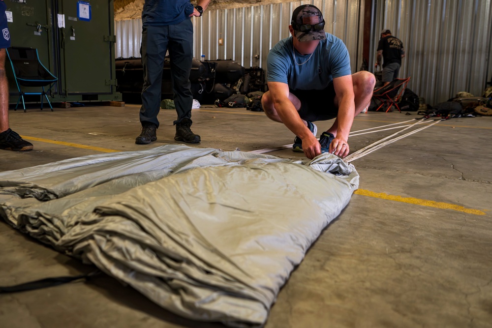 NSWG2 personnel prepare parachutes for AE25