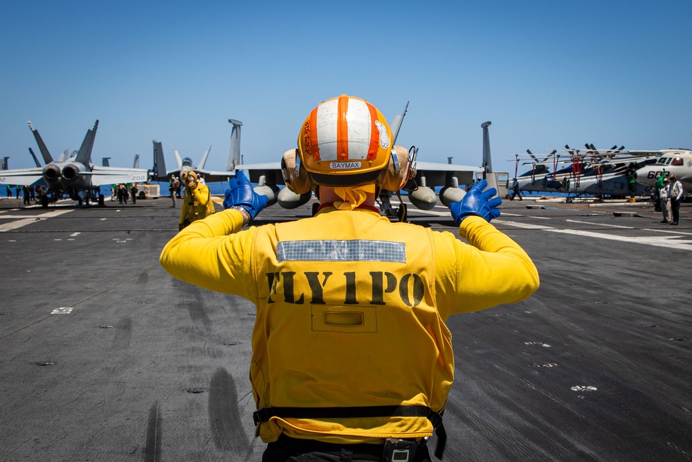 USS Gerald R. Ford (CVN 78) Sailor Signals To An F/A-18E Super Hornet