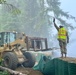 Command Sgt. Maj. Zachary Plummer assists the street team to repair a temporary flood protection barrier along the Mendenhall River