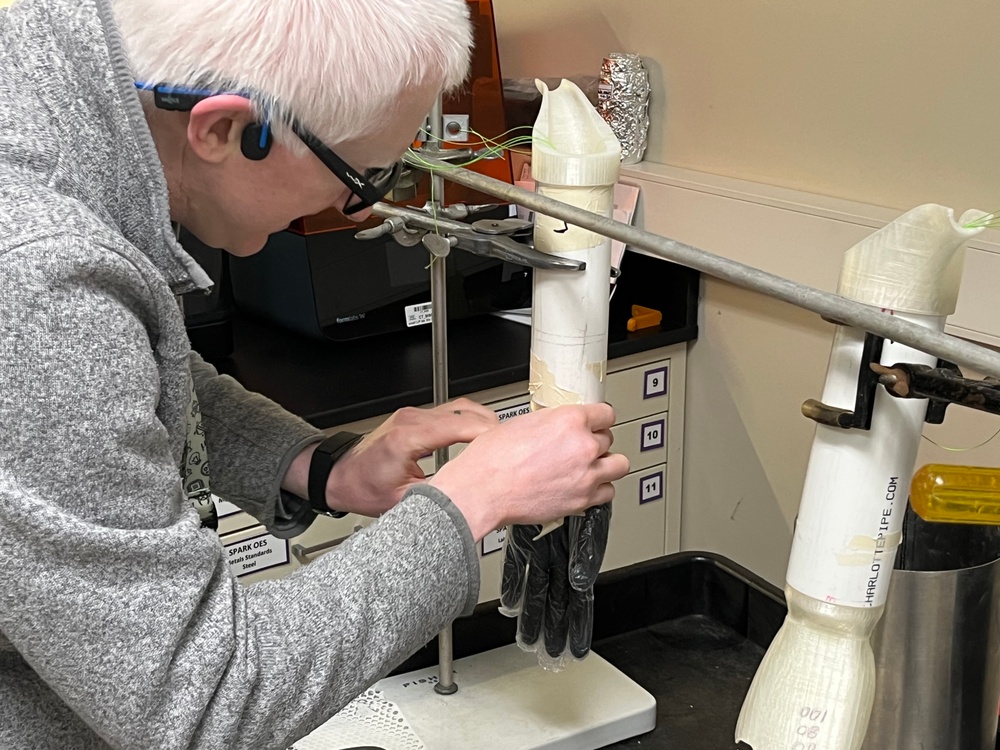 To extend the life of their 3D hand model used in glove testing, PTC engineer Edward Dalton applies a layer of rubber and plastic gloves.