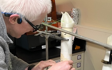 To extend the life of their 3D hand model used in glove testing, PTC engineer Edward Dalton applies a layer of rubber and plastic gloves.