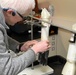 To extend the life of their 3D hand model used in glove testing, PTC engineer Edward Dalton applies a layer of rubber and plastic gloves.