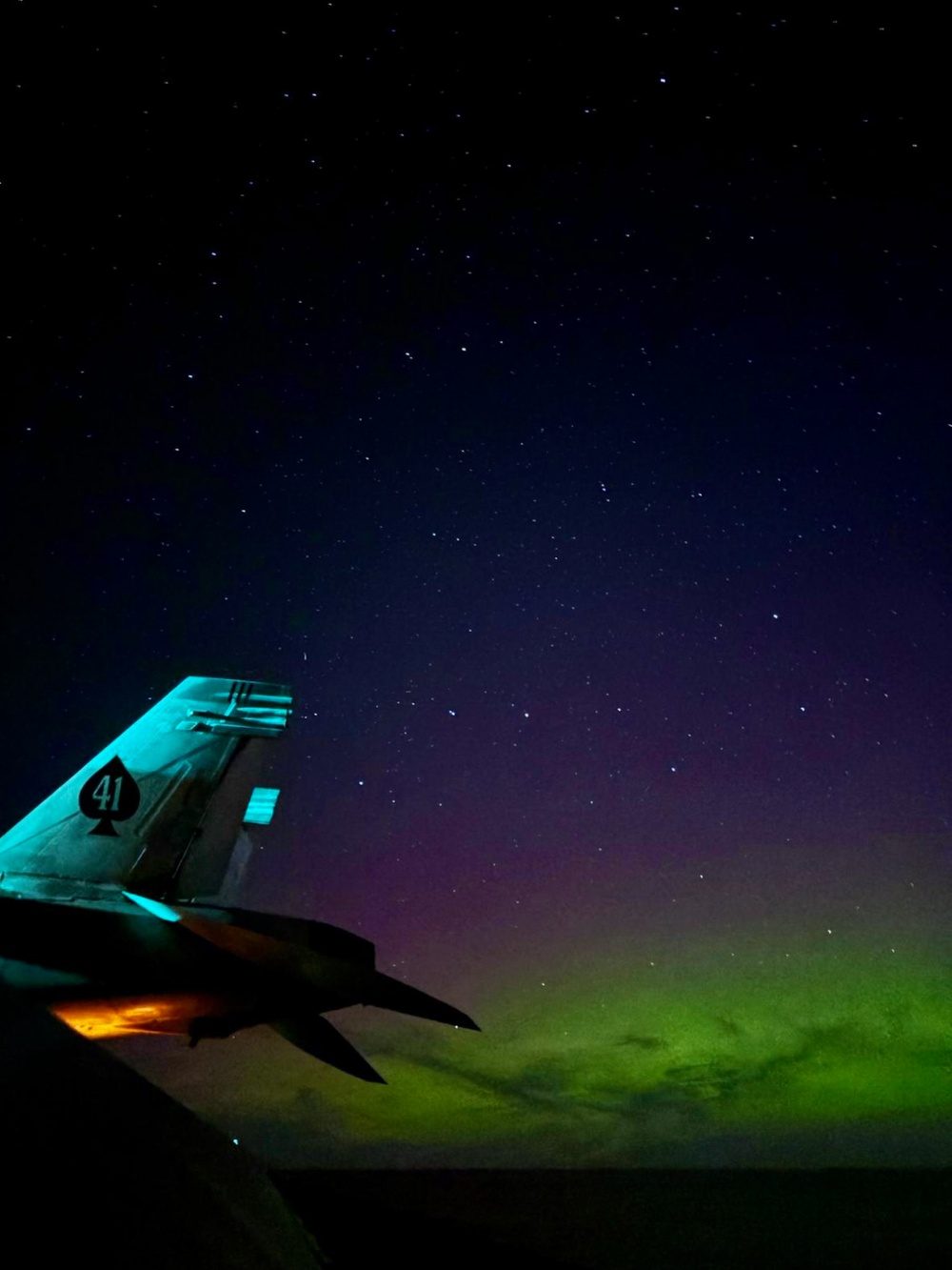 The Aurora Borealis appears over Abraham Lincoln during exercise Northern Edge 2025