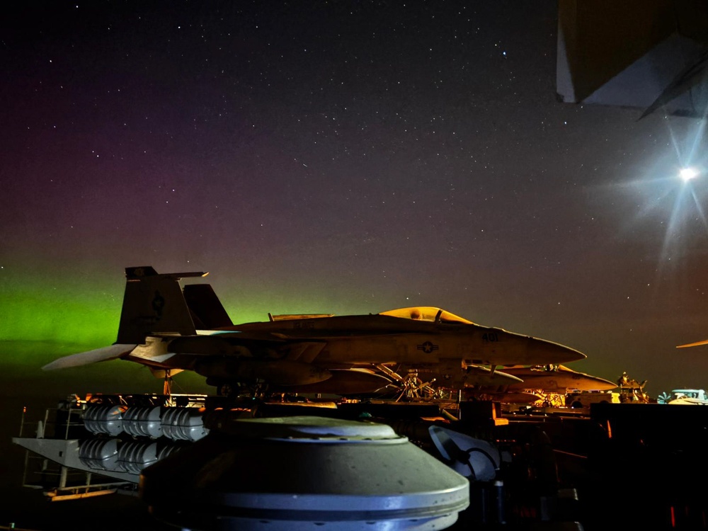 The Aurora Borealis appears over Abraham Lincoln during exercise Northern Edge 2025