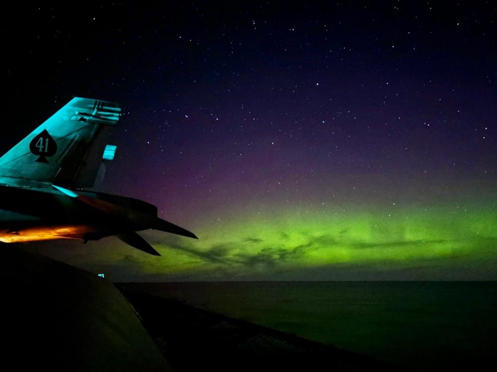 The Aurora Borealis appears over Abraham Lincoln during exercise Northern Edge 2025