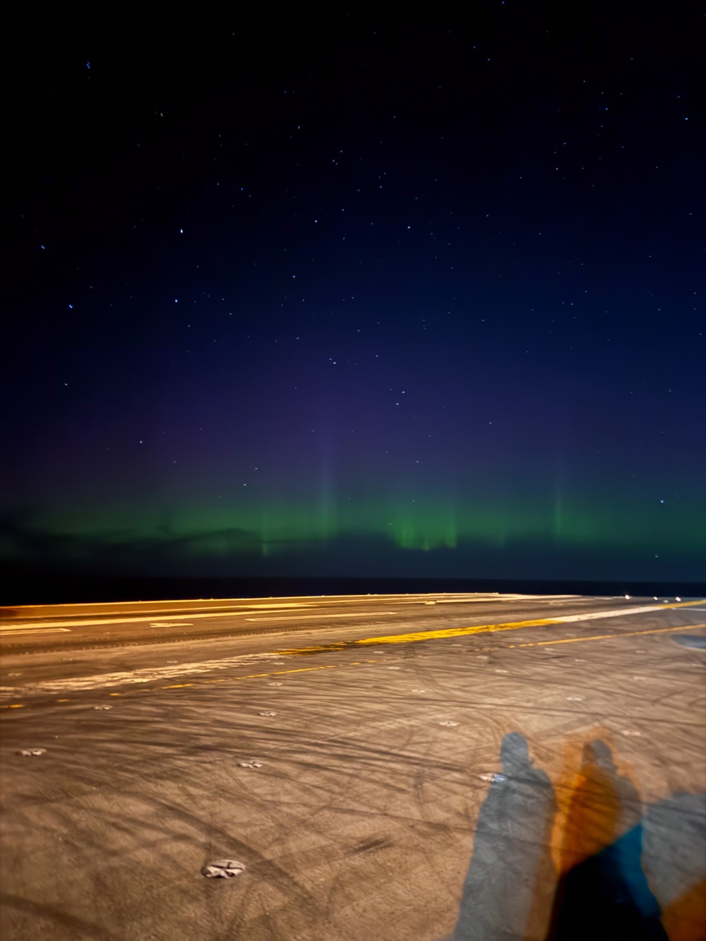 The Aurora Borealis appears over Abraham Lincoln during exercise Northern Edge 2025