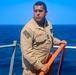 PSc Gilberto Infante steadies a fire hose during a fresh water wash down