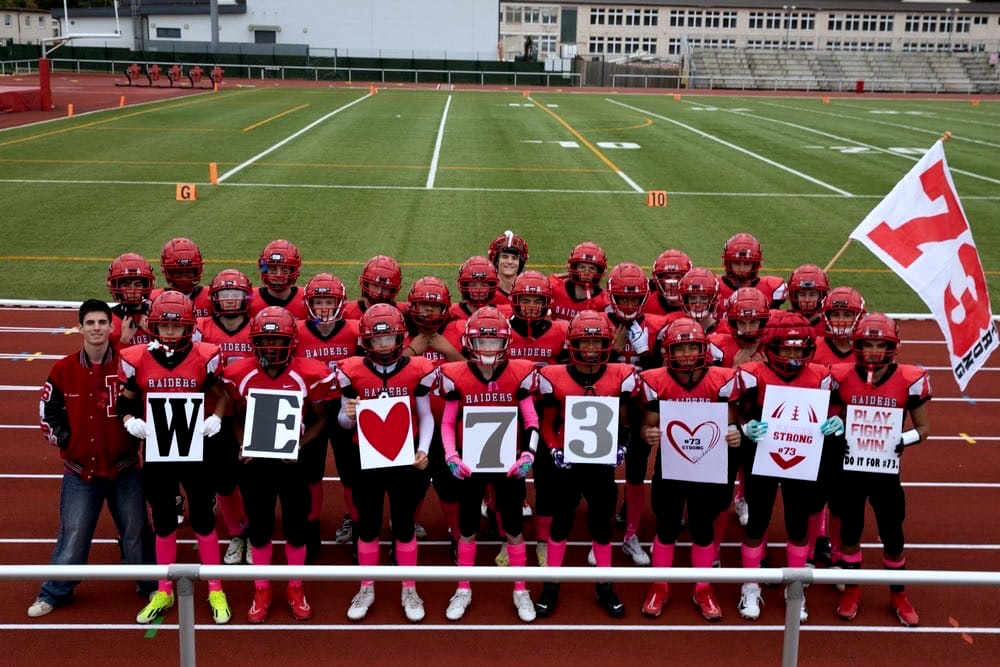 Team holding “We ♥ 73” signs