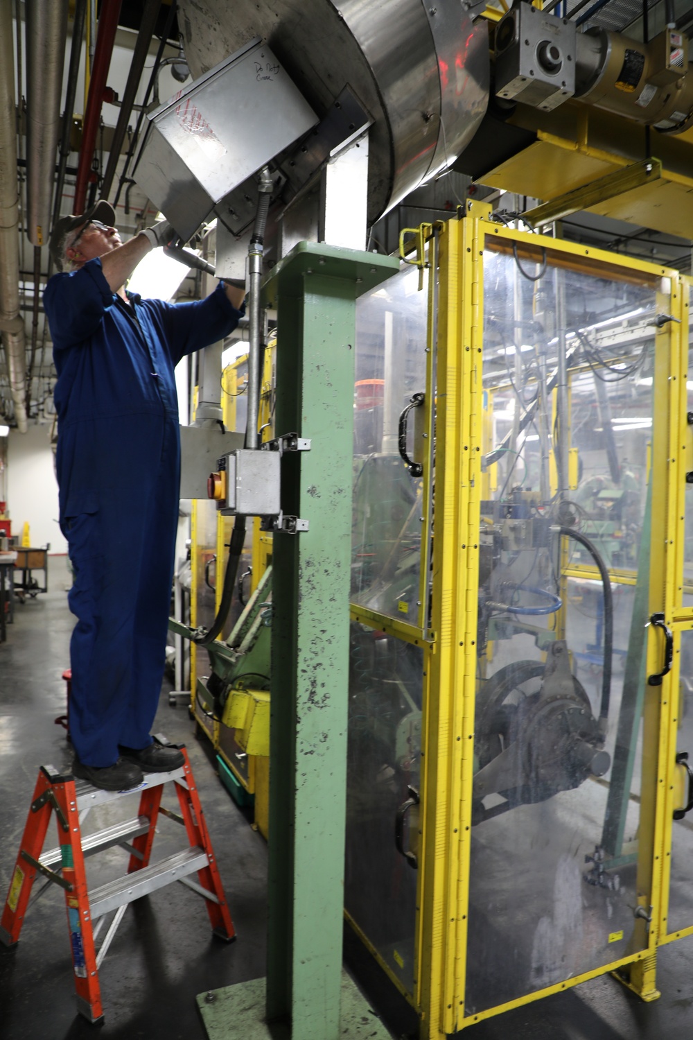 Lake City Army Ammunition Plant employee conducting routine maintenance on production line.