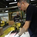 Lake City Army Ammunition Plant employee checking linked ammunition for quality prior to packaging.