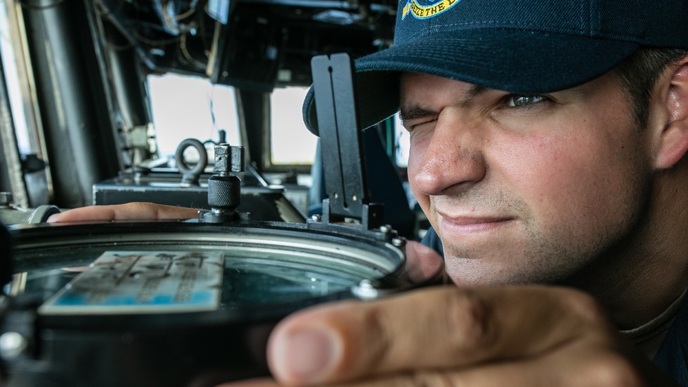 USS Mitscher (DDG 57) junior officer looks through navigational alidade