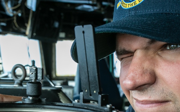 USS Mitscher (DDG 57) junior officer looks through navigational alidade