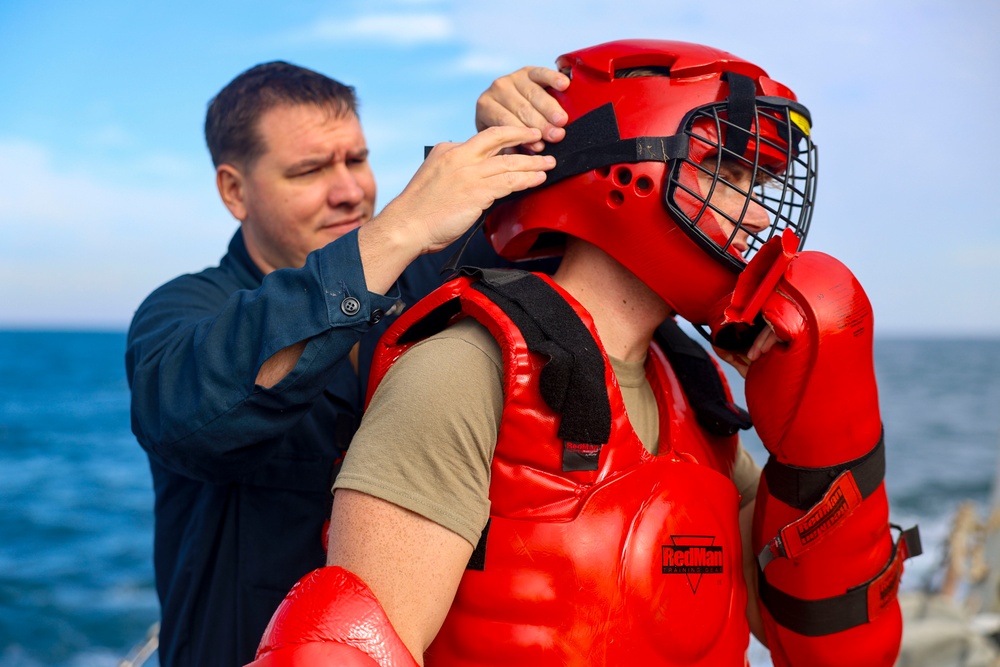 OS1 Casey Leverett and OS2 Kurt Goldsmith prepare for Non-Lethal Weapons training