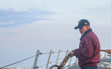 BM3 Jonathon Reynolds heaves in a mooring line from a tug boat during sea-and-anchor detail