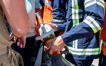 USAF and partner nation service members participate in a joint fire vehicle inspection