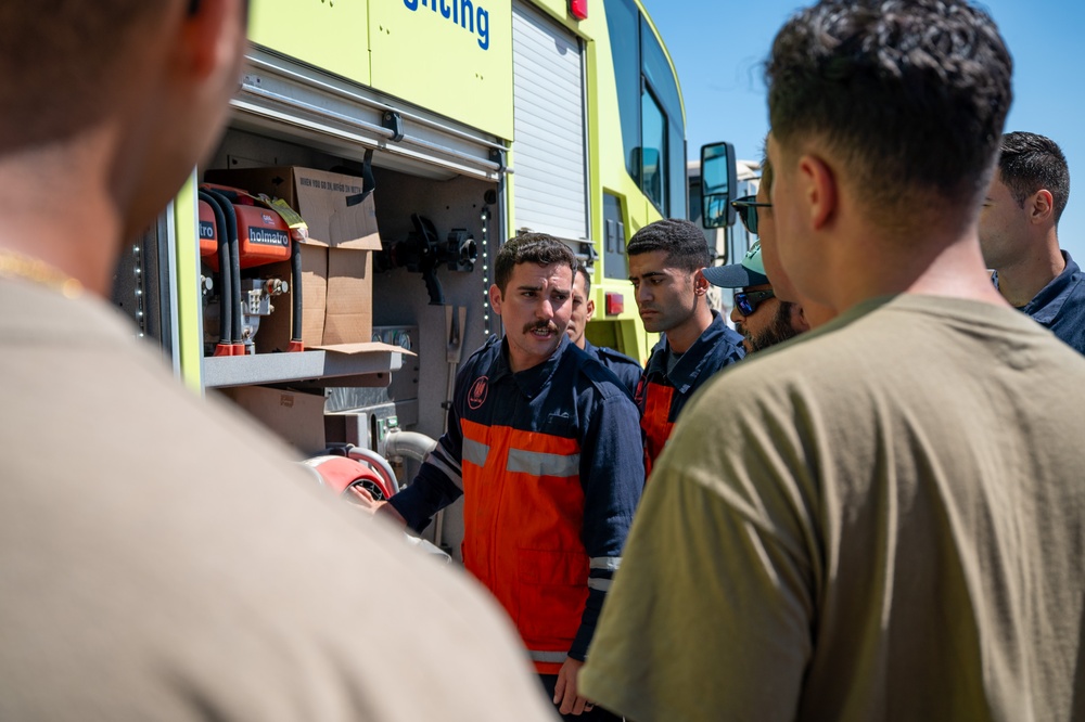 USAF and partner nation service members participate in a joint fire vehicle inspection