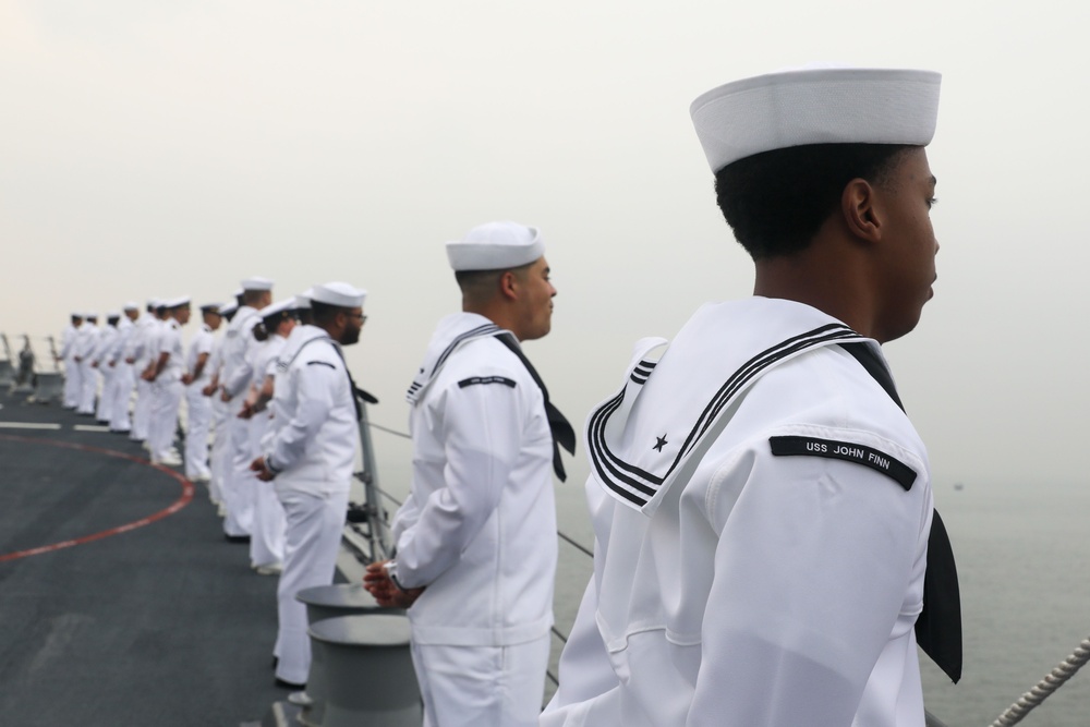 Sailors aboard the USS John Finn man the rails during a sea and anchor detail in Jakarta, Indonesia