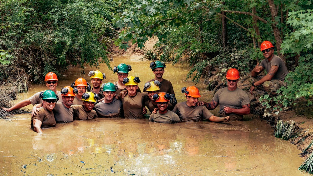 U.S. Army Soldiers trainees and instructors pose for a class photo while standing in the mire pit during the Wheeled Vehicle Recovery Operations Course held at the 139th Regional Training Institute in Fort Bragg, NC, August 8, 2025.