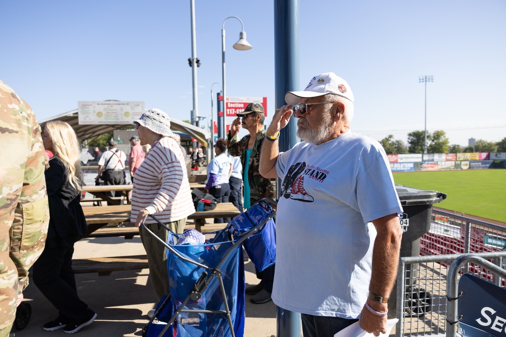Veteran volunteer salutes during National Anthem at Five Seasons Stand Down