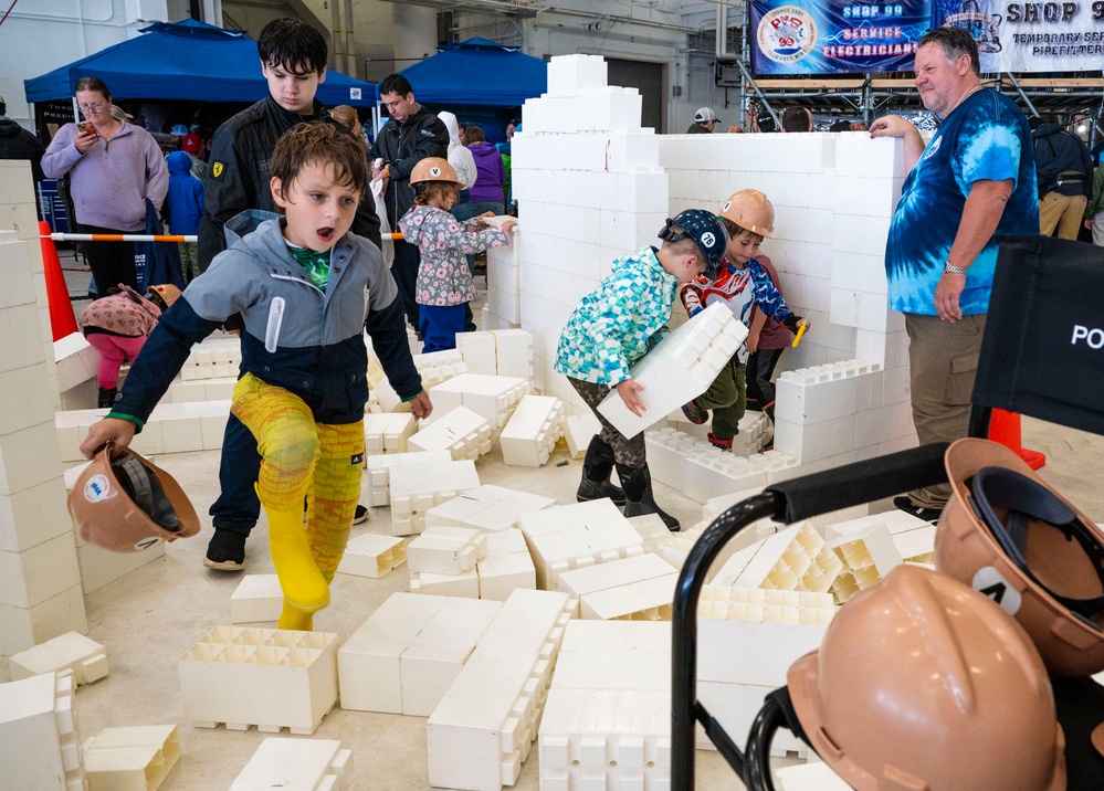 Children imitating construction workers and build model buildings at STEM event