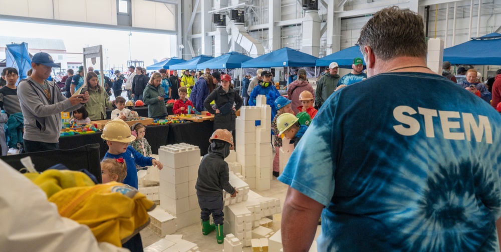Children portray construction workers and build model buildings at STEM exhibit