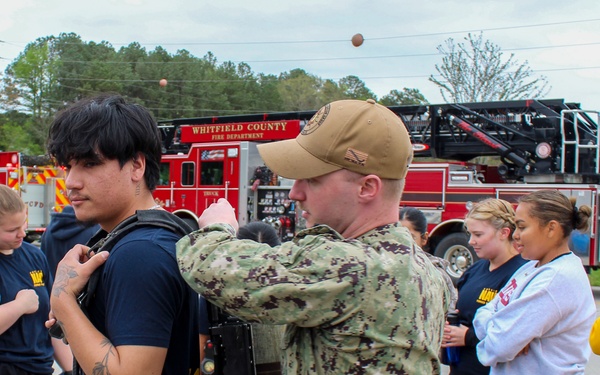 Navy Recruiter Assists Delayed Entry Member With Donning Fire Fighting Gear