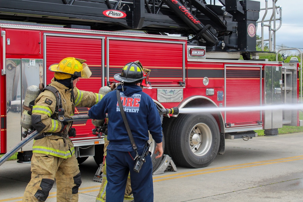 Delayed Entry Members Use A Fire Hose