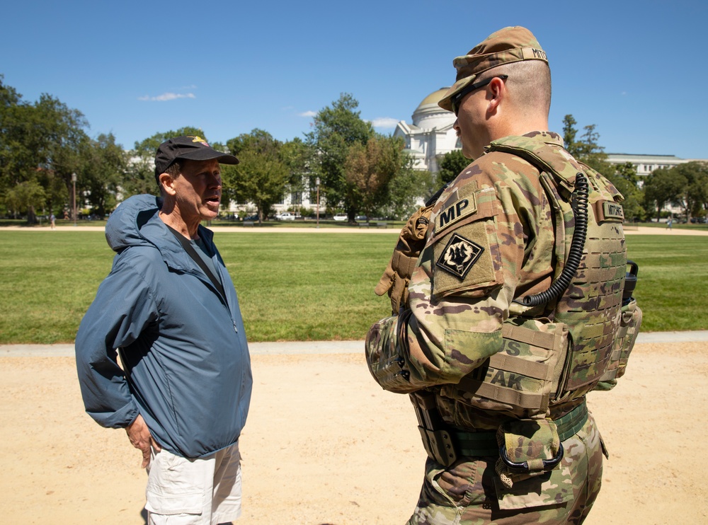 A U.S. Army Soldier, with the 112th Military Police Battalion, MS National Guard, speaks with a local resident at the National Mall
