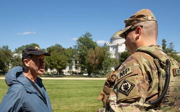 A U.S. Army Soldier, with the 112th Military Police Battalion, MS National Guard, speaks with a local resident at the National Mall