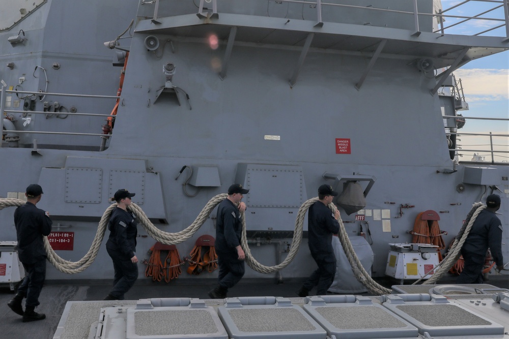 Sailors aboard the USS John Finn conduct a sea and anchor detail In Changi, Singapore