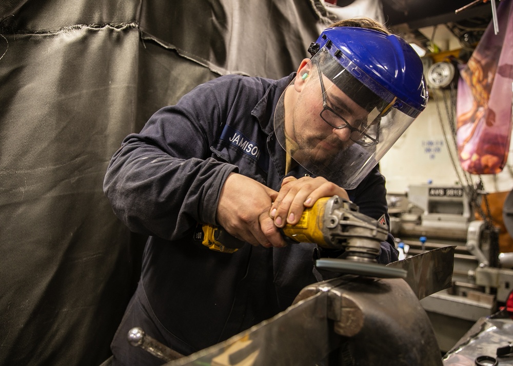 USS Mitscher (DDG 57) Sailor conducts machine shop maintenance
