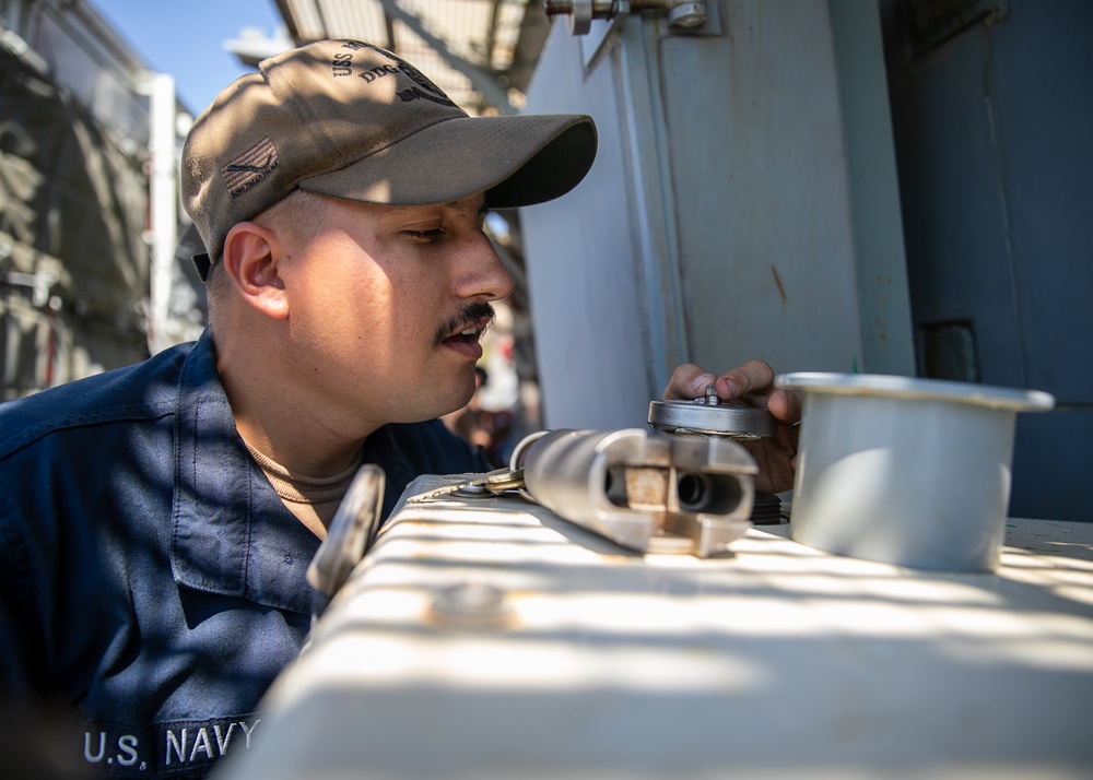 USS Mitscher (DDG 57) Sailor checks locker temperatures