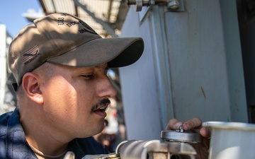 USS Mitscher (DDG 57) Sailor checks locker temperatures